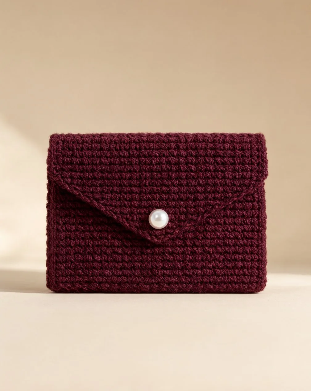 Foto prodotto della Clutch Perla, pochette all'uncinetto borgogna con chiusura a perla